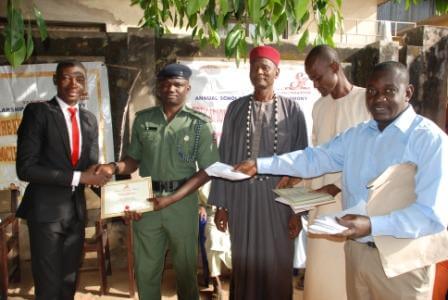 Best student from Command Day secondary school North Bank, Makurdi, Mr. Onah Samuel Adokole receiving his award from Captain M Abdullah during the 2015 Tanimu foundation award ceremony.