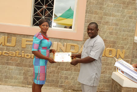 Director presenting a certificate to one graduate
